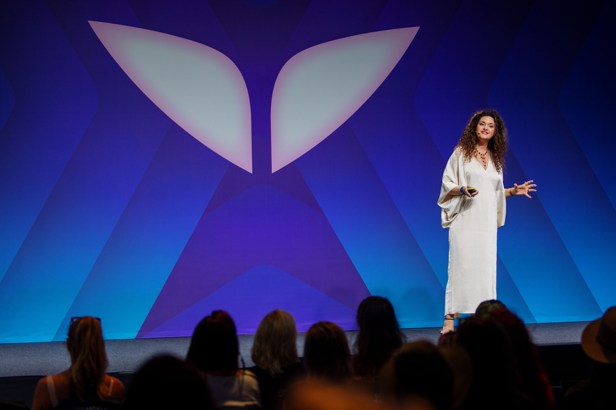 Dr. Jolene Brighten speaking on stage to a large audience